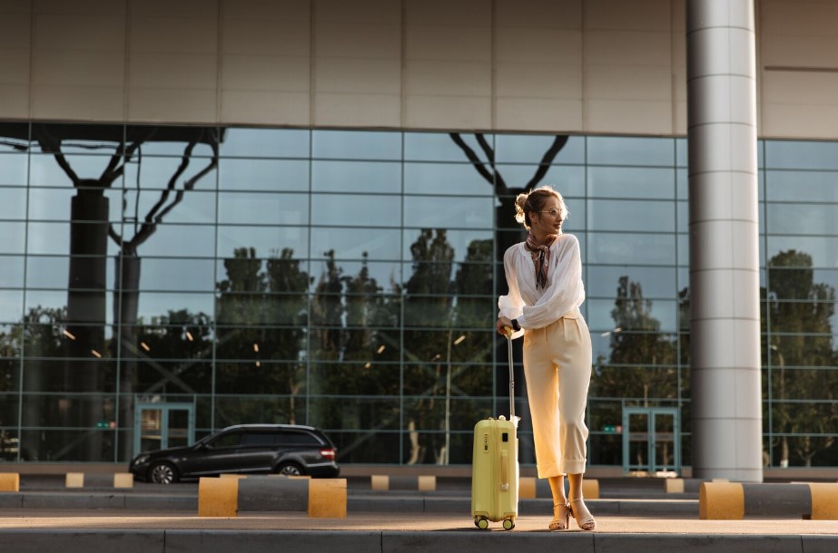 charming-blonde-woman-white-blouse-beige-pants-eyeglasses-moves-near-airport