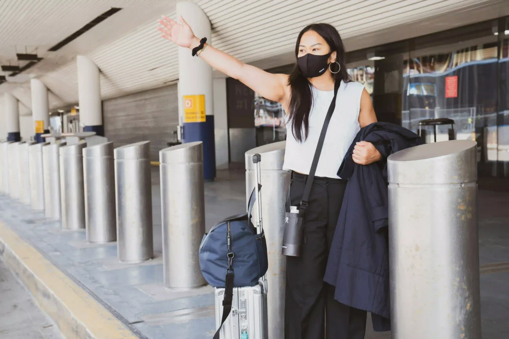 Reiziger wacht buiten de luchthaven met bagage op een vooraf geboekte transfer