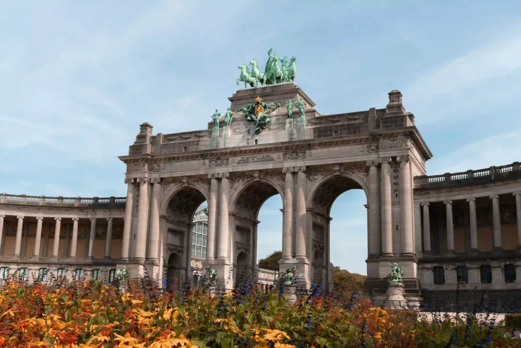 The Triumphal Arch in the Jubelpark in Brussels with colorful flowerbeds in the foreground.